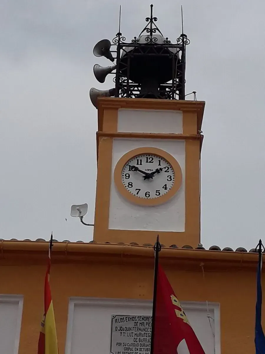Un reloj en la parte superior de un edificio que dice 'ayuntamiento'.