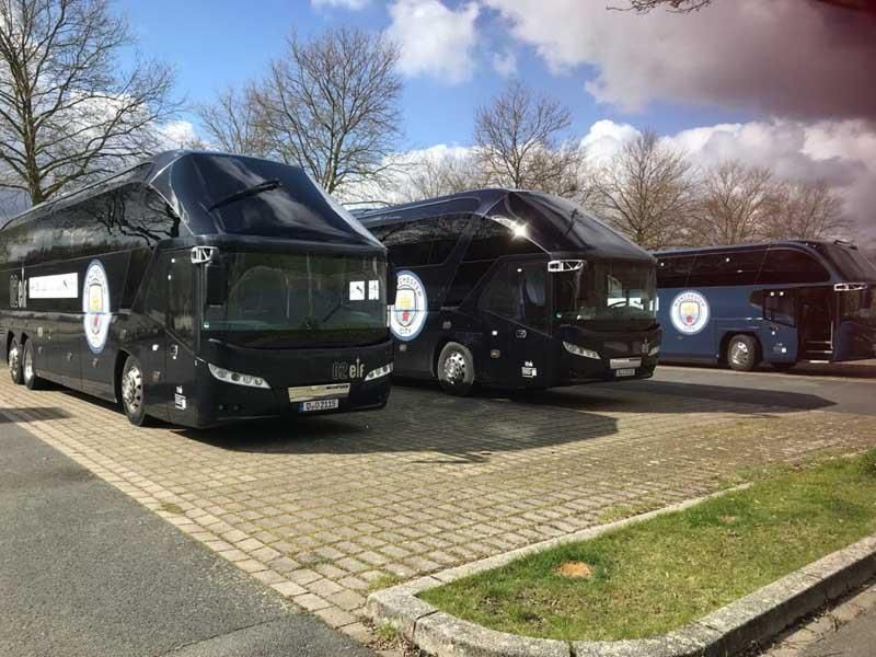 Drei schwarze Busse stehen nebeneinander auf einem Parkplatz.