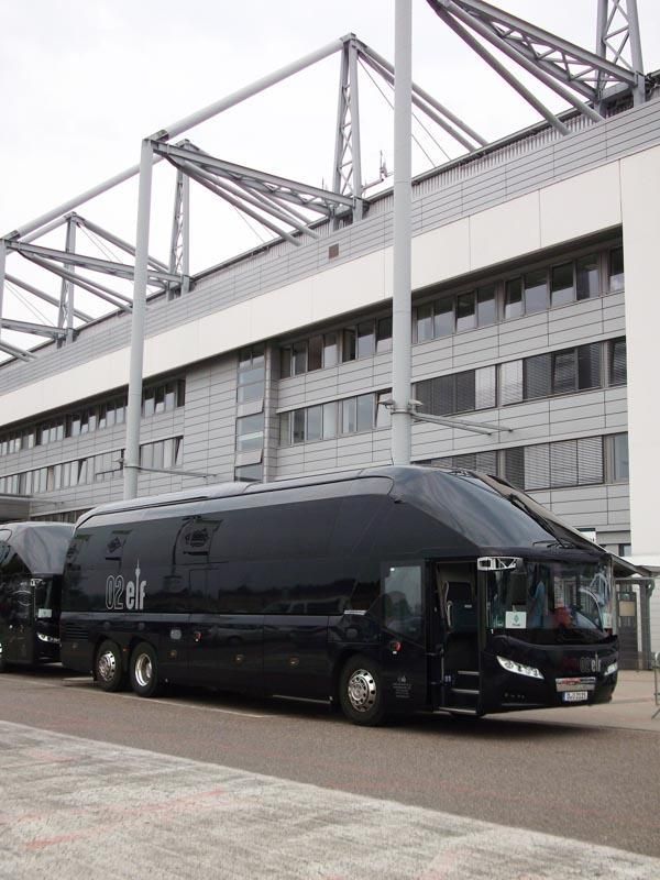 Ein großer schwarzer Bus steht vor einem großen Gebäude