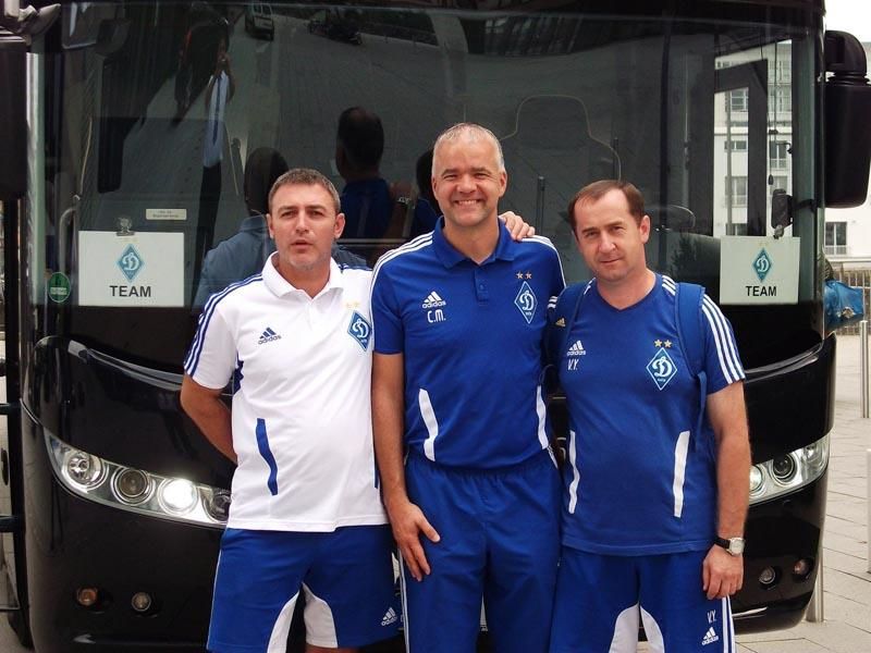 Drei Männer stehen vor einem Bus mit der Aufschrift TFCM