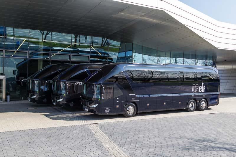 Eine Reihe blauer Busse parken vor einem Gebäude