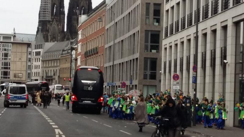 Eine Gruppe von Menschen geht eine Straße vor einem großen Gebäude entlang