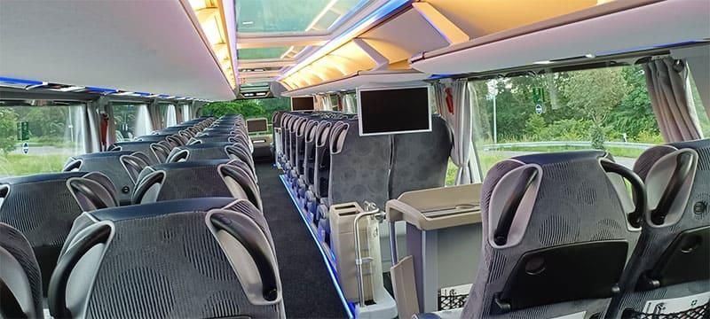 Ein Bus mit vielen Sitzen und einem Fernseher an der Decke