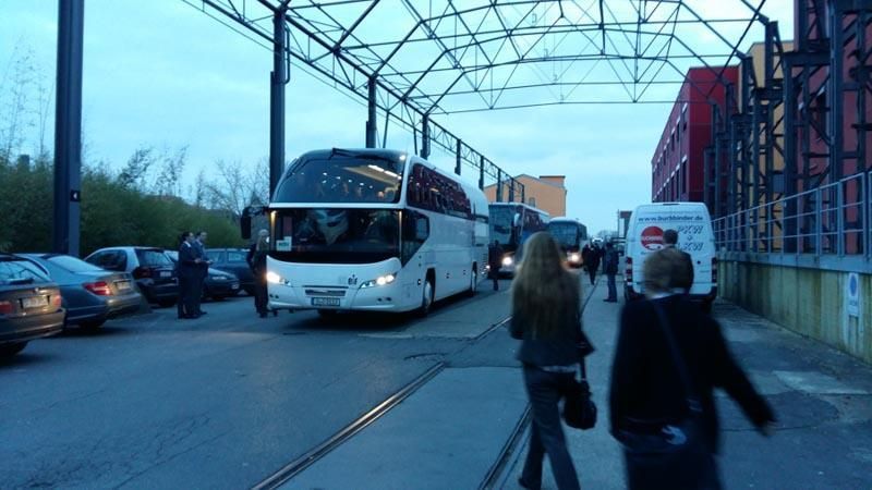 Eine Reihe weißer Busse stehen auf einem Parkplatz