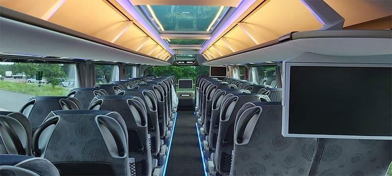 Das Innere eines Busses mit einem an der Decke montierten Fernseher.