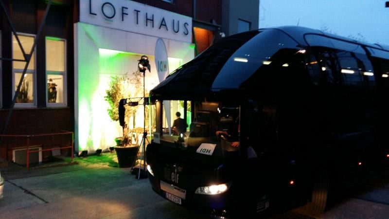 Ein schwarzer Bus parkt vor einem Gebäude mit der Aufschrift Lofthaus