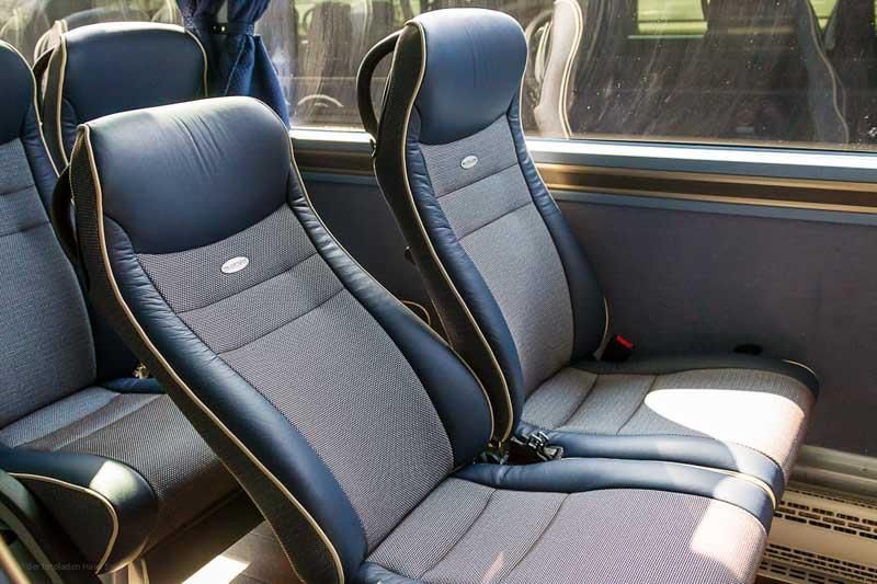 Eine Reihe blauer und grauer Sitze in einem Bus