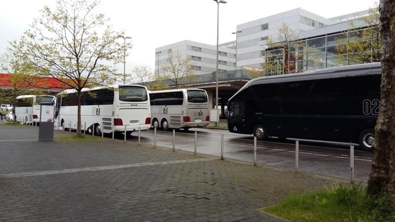 Eine Reihe von Bussen stehen auf einem Parkplatz mit der Nummer 02 auf der Seite