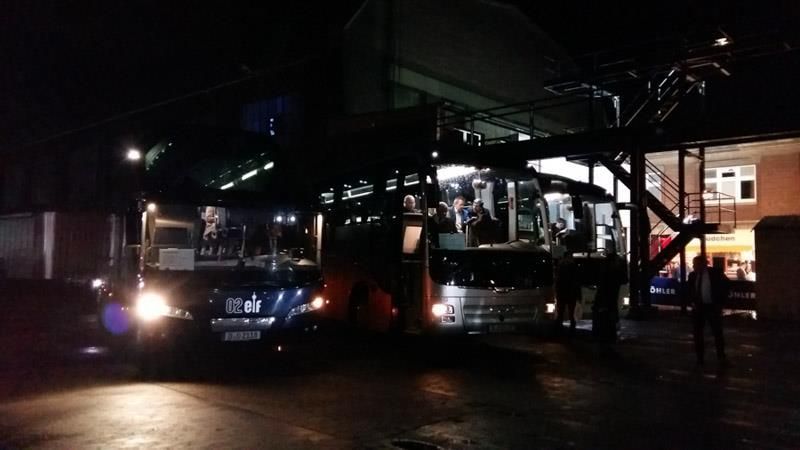 Ein paar Busse stehen auf einem dunklen Parkplatz