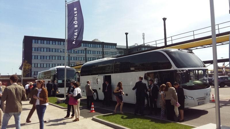 Eine Gruppe von Menschen steigt vor einem Gebäude in einen Bus