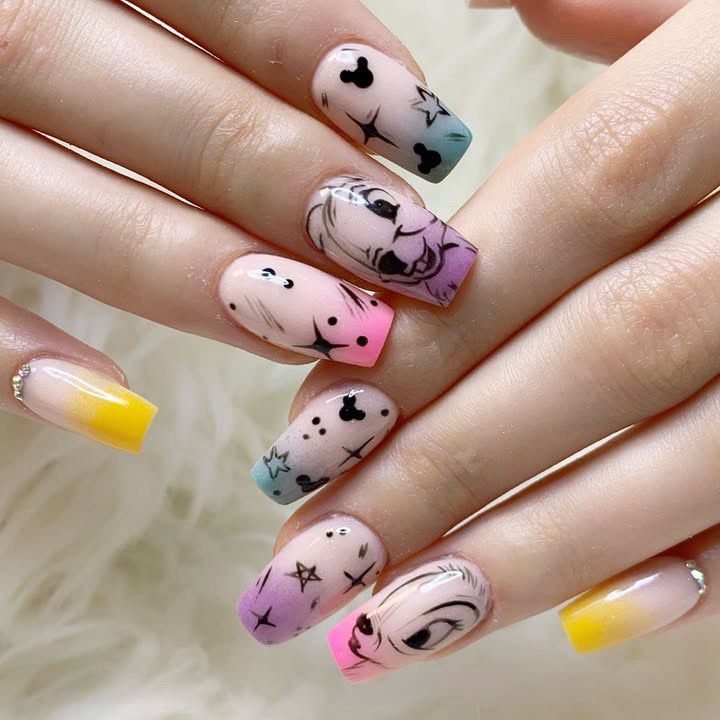 Uñas cuadradas con degradados pastel y nail art con temática de Disney, incluyendo estrellas y caras de personajes.