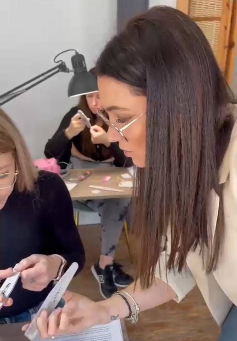 Manos con uñas cuadradas en estilo manicura francesa, con base rosa claro y puntas blancas.