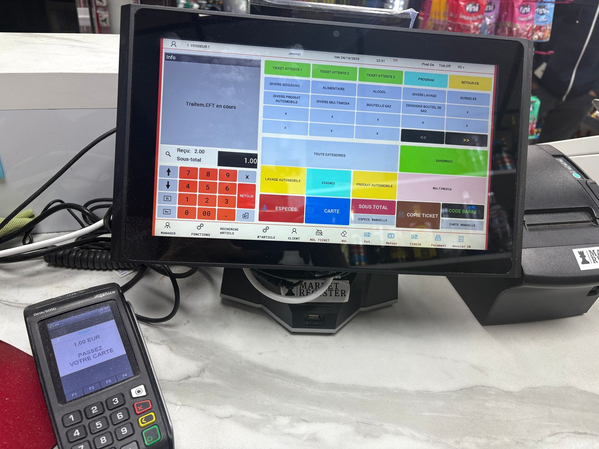 Une caisse enregistreuse noire sur une table blanche.