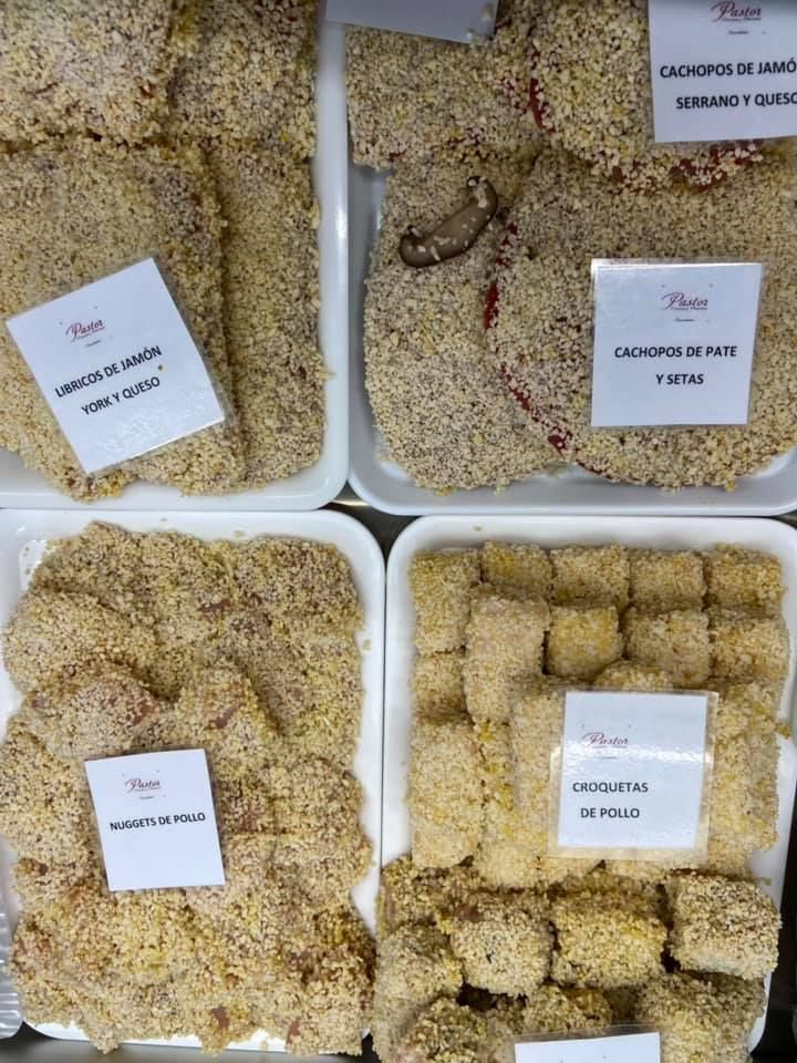 Bandejas de comida preparada: diversos productos empanizados, incluidas chuletas y croquetas, etiquetados en español.