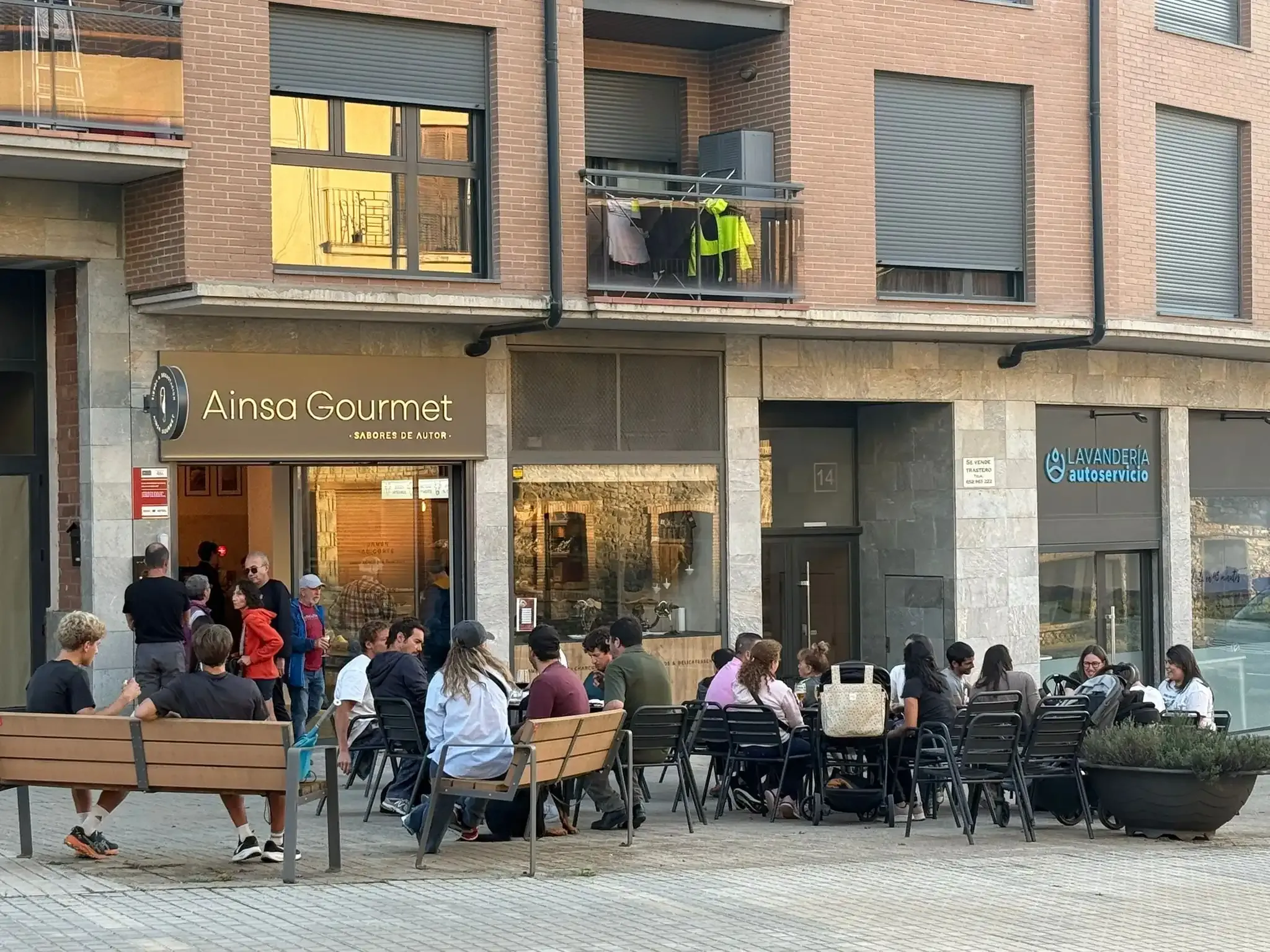 Personas sentadas en mesas al aire libre frente a la tienda 