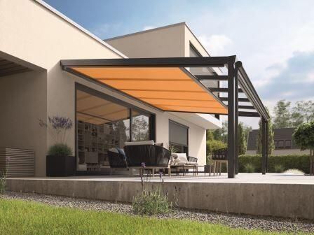 Terrasse mit orangefarbener, ausfahrbarer Markise, Teil eines modernen Hauses, sonniger Tag.