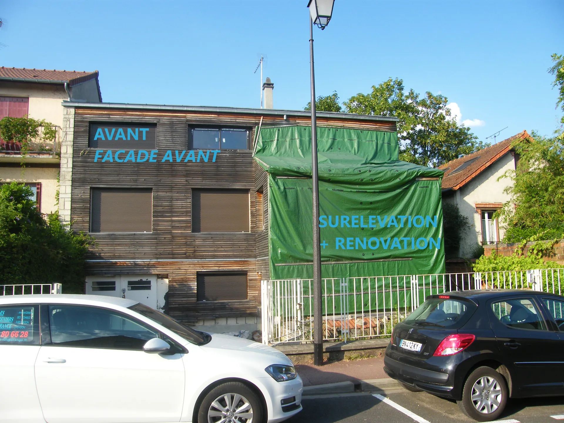 Façade d'immeuble en rénovation, recouverte d'une bâche verte, inscription : « AVANT », « SURÉLÉVATION + RÉNOVATION », voitures garées devant.
