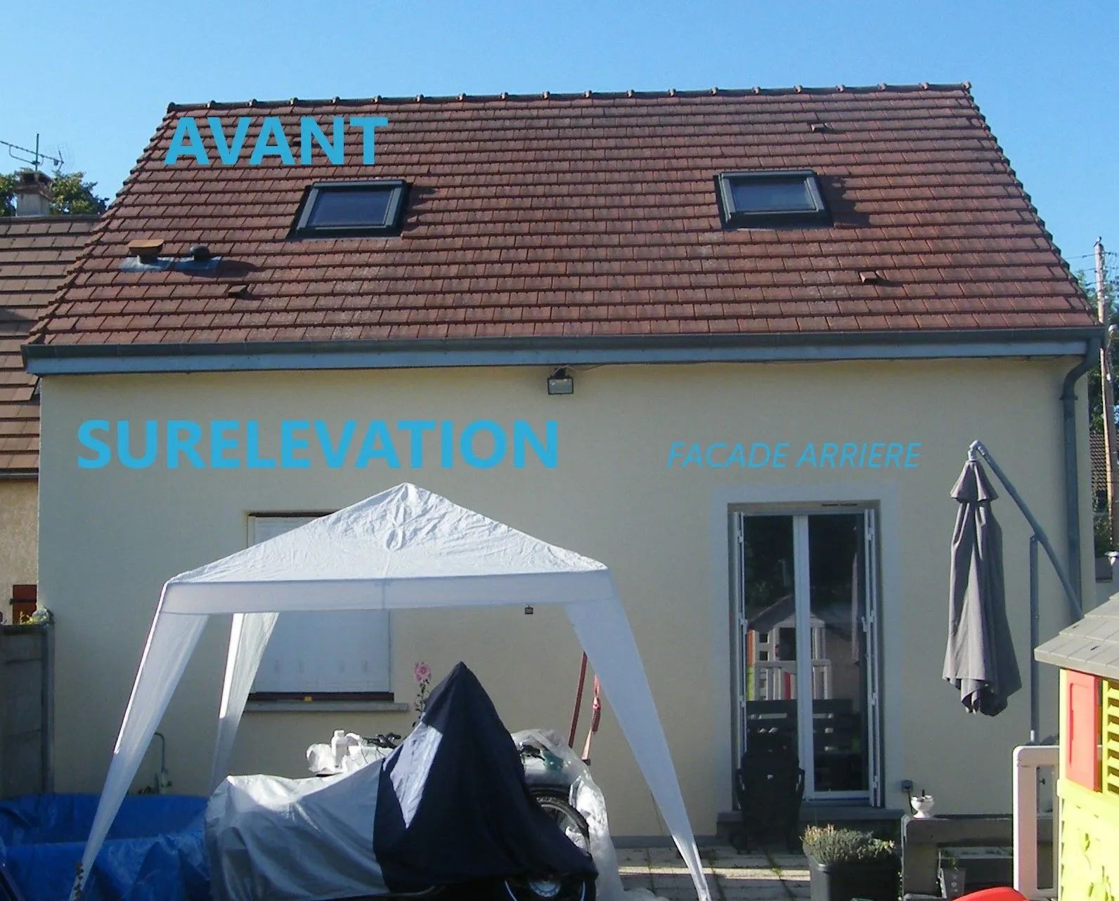 Vue extérieure d'une maison avant l'extension du toit. Inscriptions superposées : « AVANT » et « SURELEVATION ». Puits de lumière et parasol de terrasse visibles.