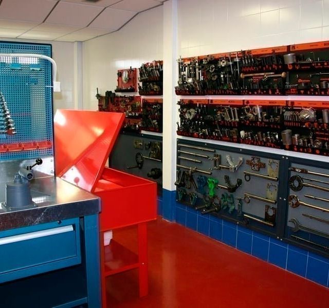Una habitación llena de muchas herramientas, incluida una caja roja.