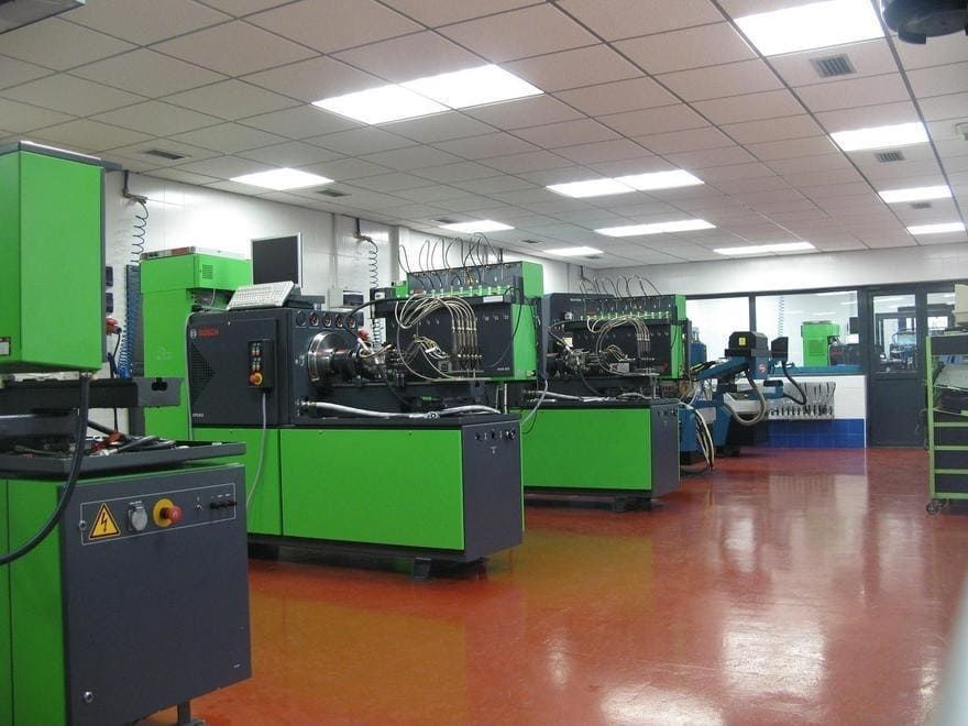 Una gran sala llena de maquinaria verde y gris.