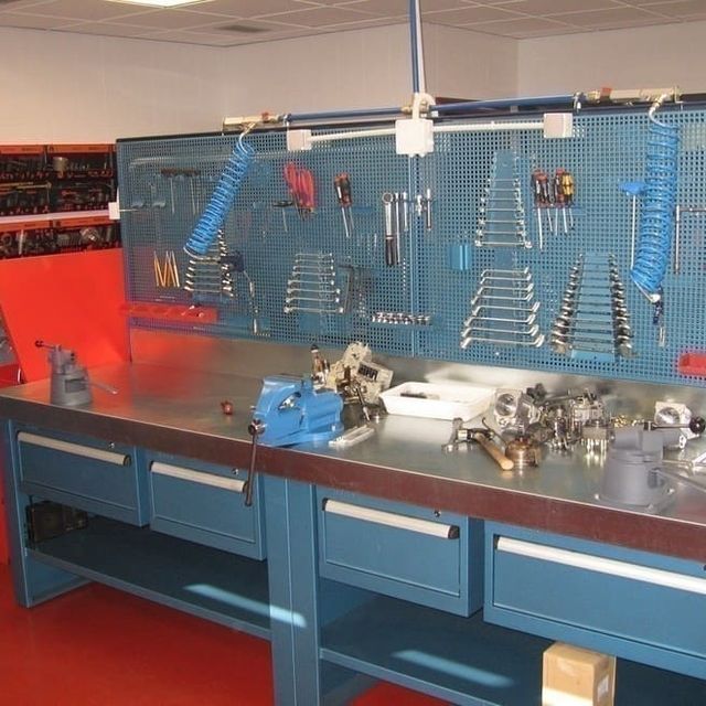 Un banco de trabajo con muchas herramientas encima.