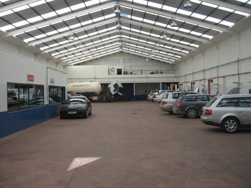 Hay muchos coches aparcados dentro de un edificio.