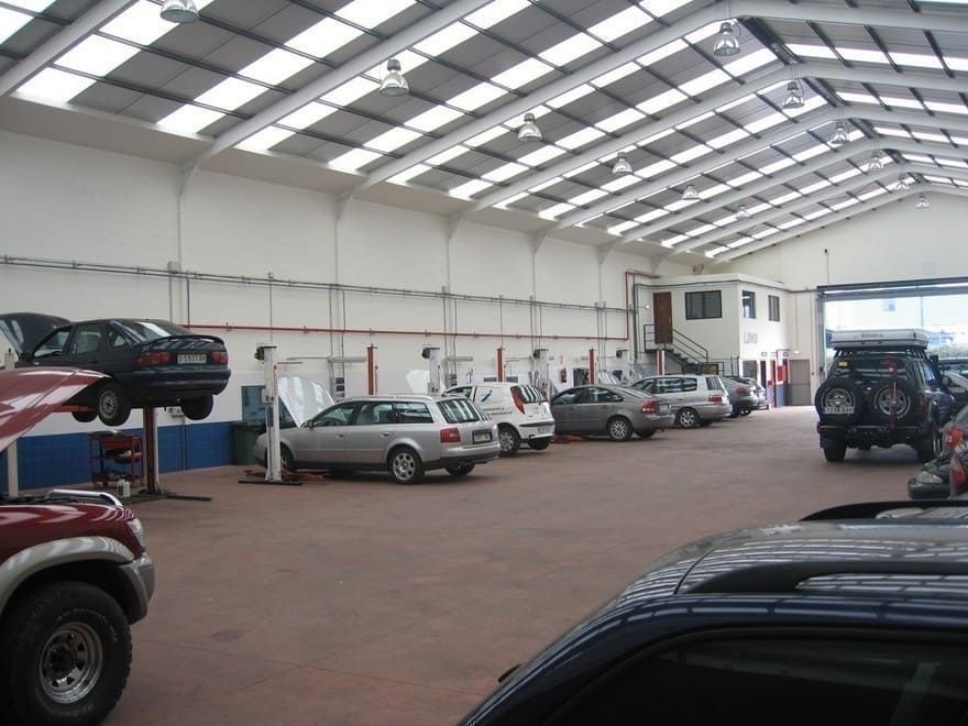 Una fila de coches están aparcados dentro de un garaje.