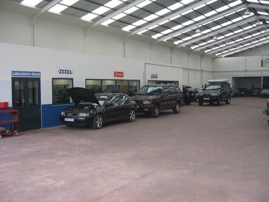 Una fila de coches están aparcados en un garaje con un cartel que dice 'ii' en él