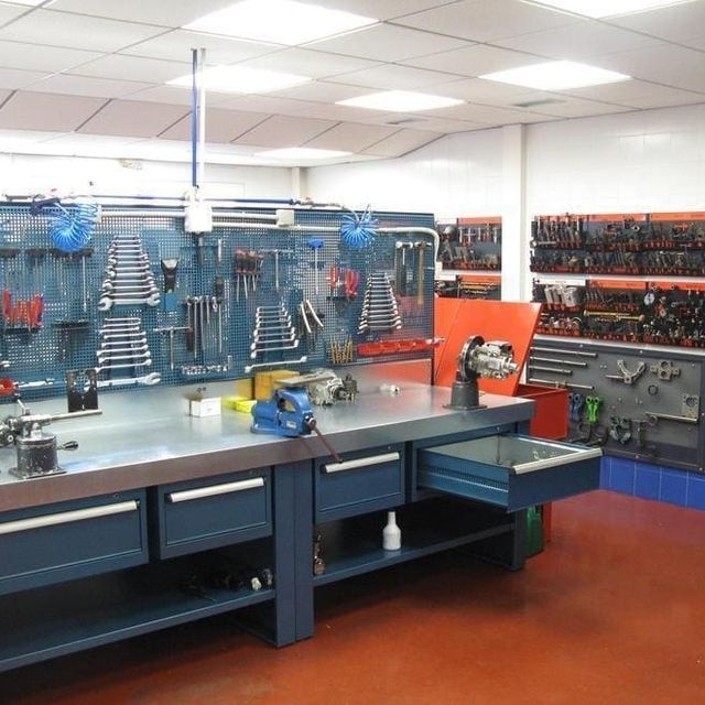 Un banco de trabajo con muchas herramientas colgadas en la pared.