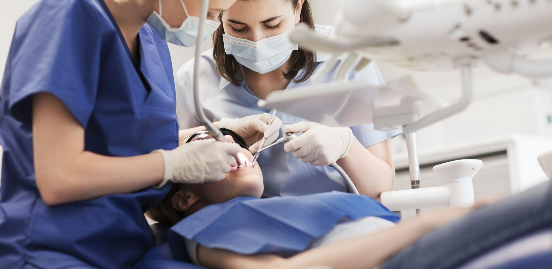 Deux dentistes en cours d'intervention sur un patient.