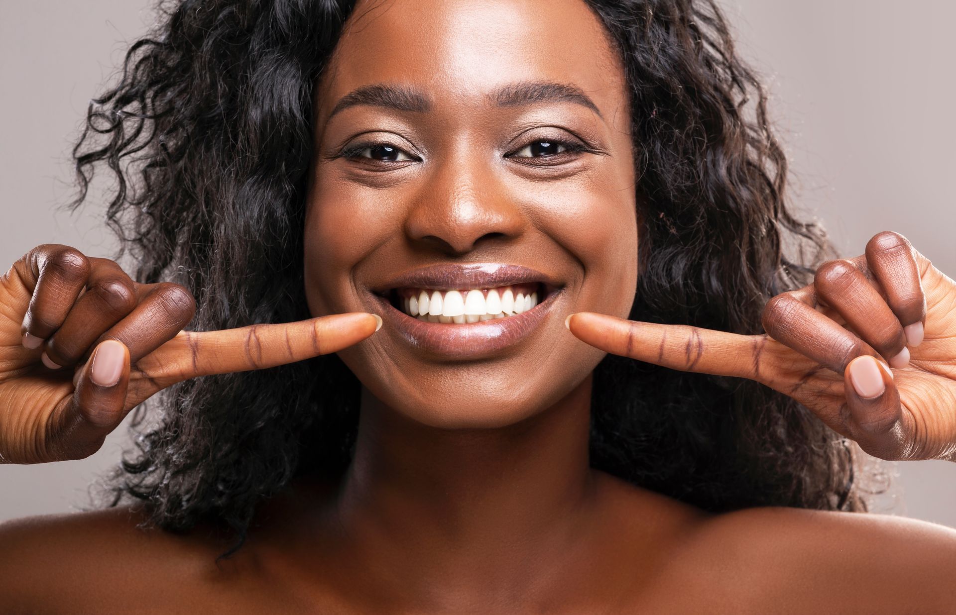 Femme qui montre ses dents après un blanchiment dentaire.