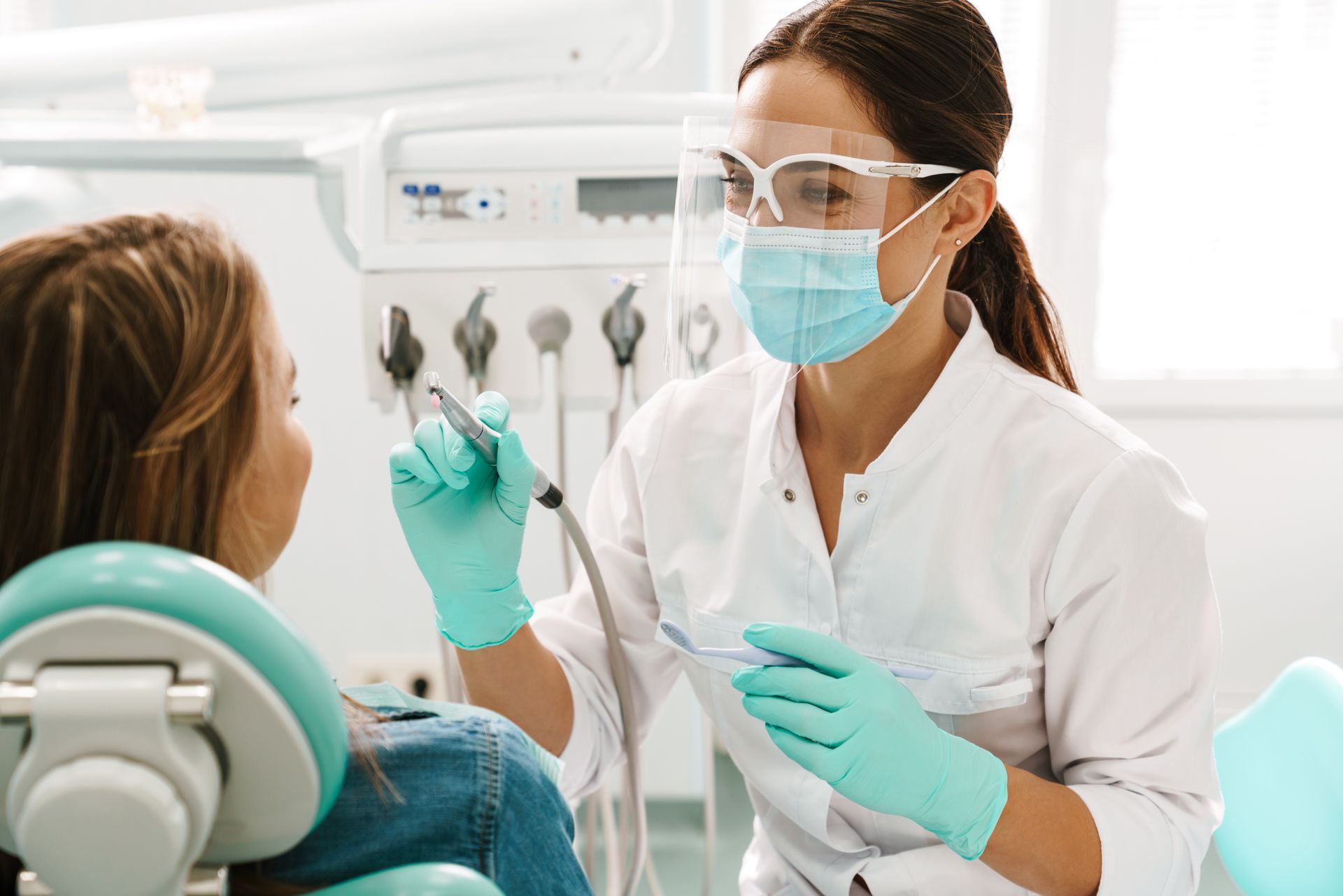 Une dentiste examine les dents d'une jeune fille dans un cabinet dentaire.