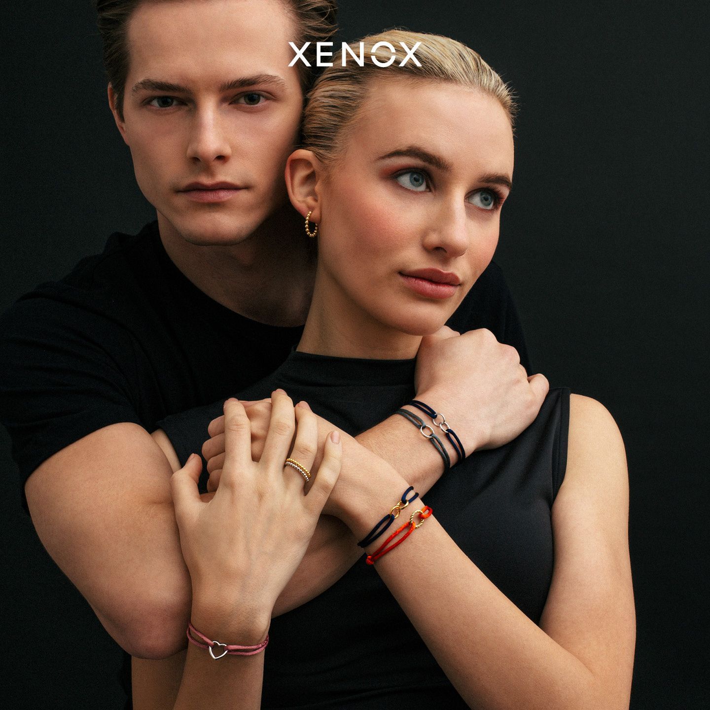 Ein Mann und eine Frau tragen Xenox-Armbänder