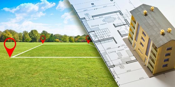 Un terrain marqué de punaises, de plans et d'une maison miniature.