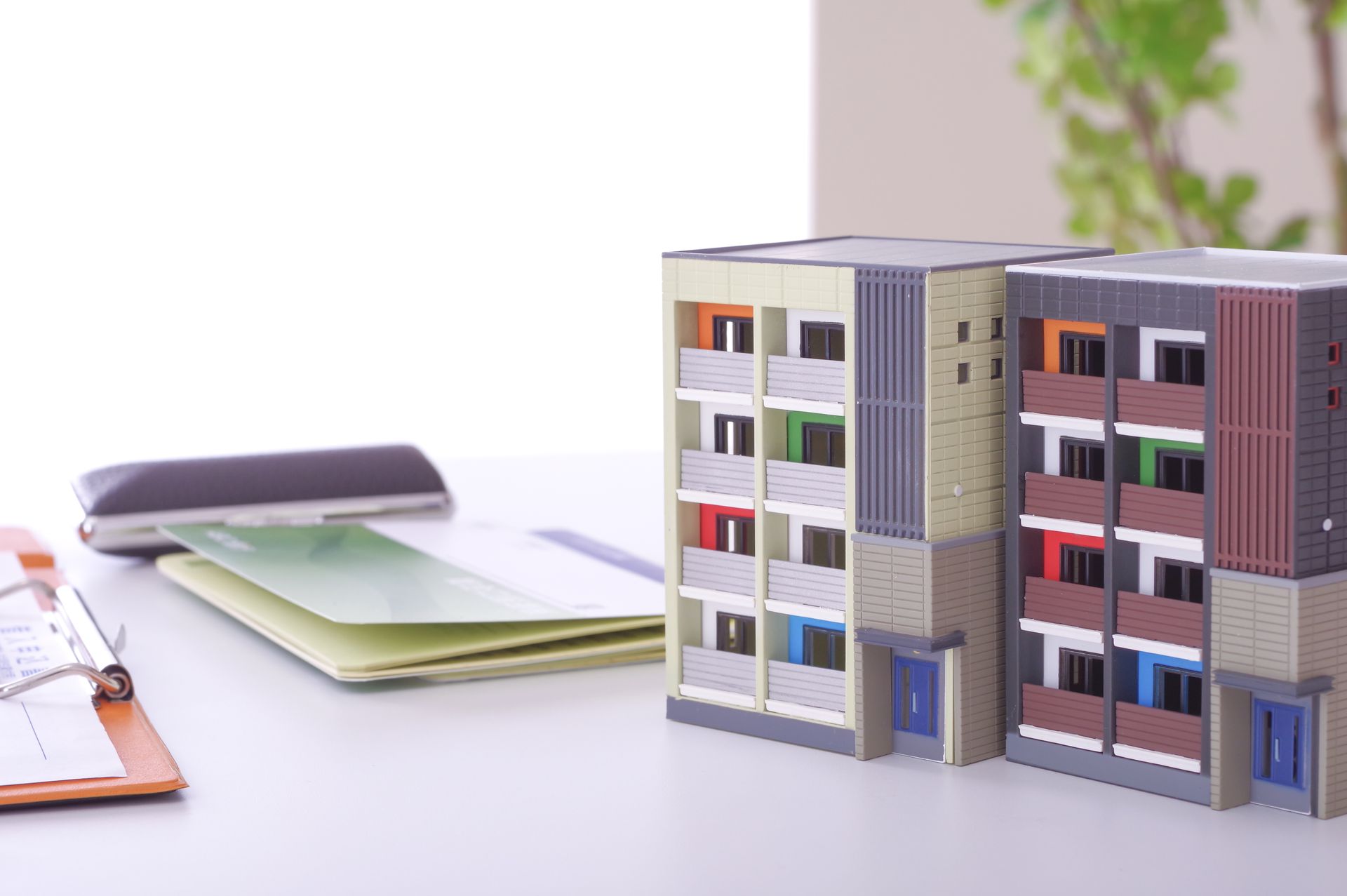 Maquettes d'immeubles, chéquier, documents sur un bureau.