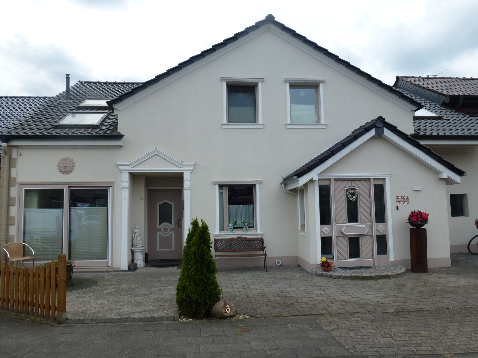 Ein weißes Haus mit schwarzem Dach und einem davor geparkten Fahrrad