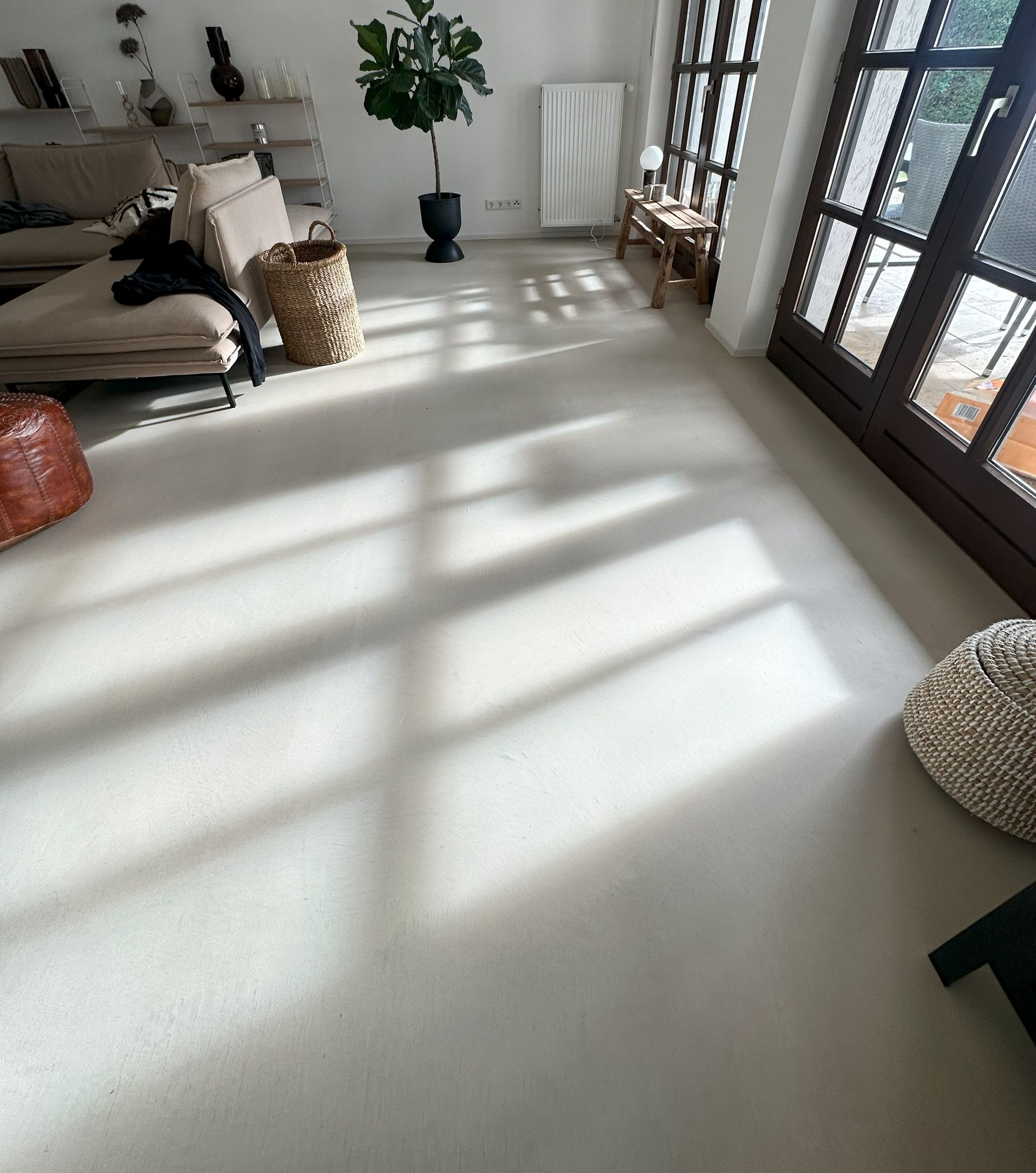 Ein Wohnzimmer mit Sofa, Sessel und Topfpflanze.