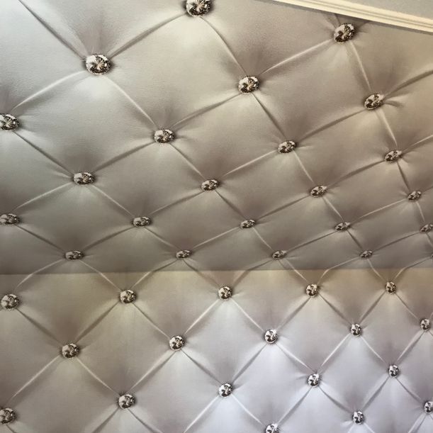 Eine weiße Steppdecke mit Knöpfen darauf