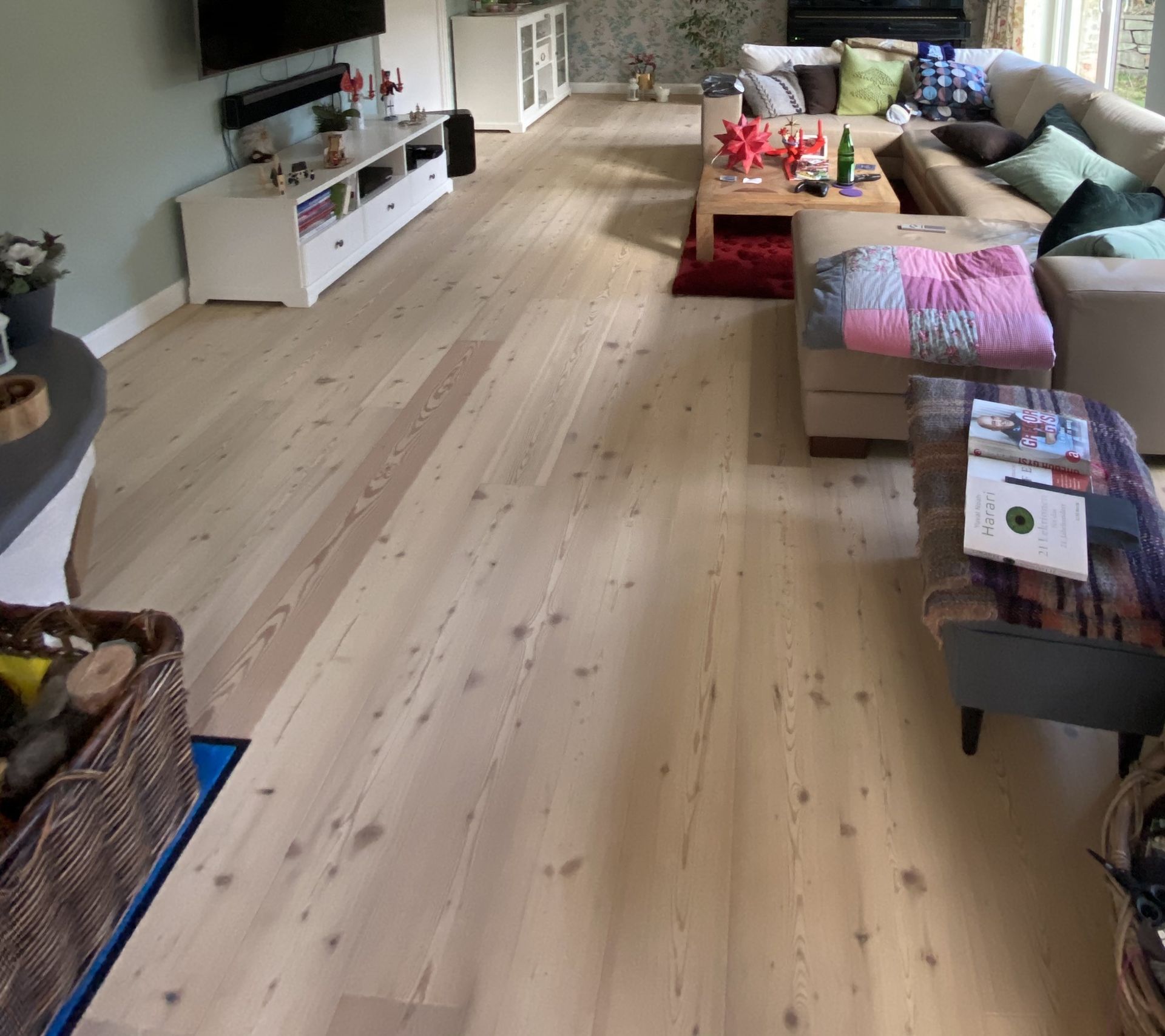 Ein Wohnzimmer mit Holzboden und vielen Möbeln