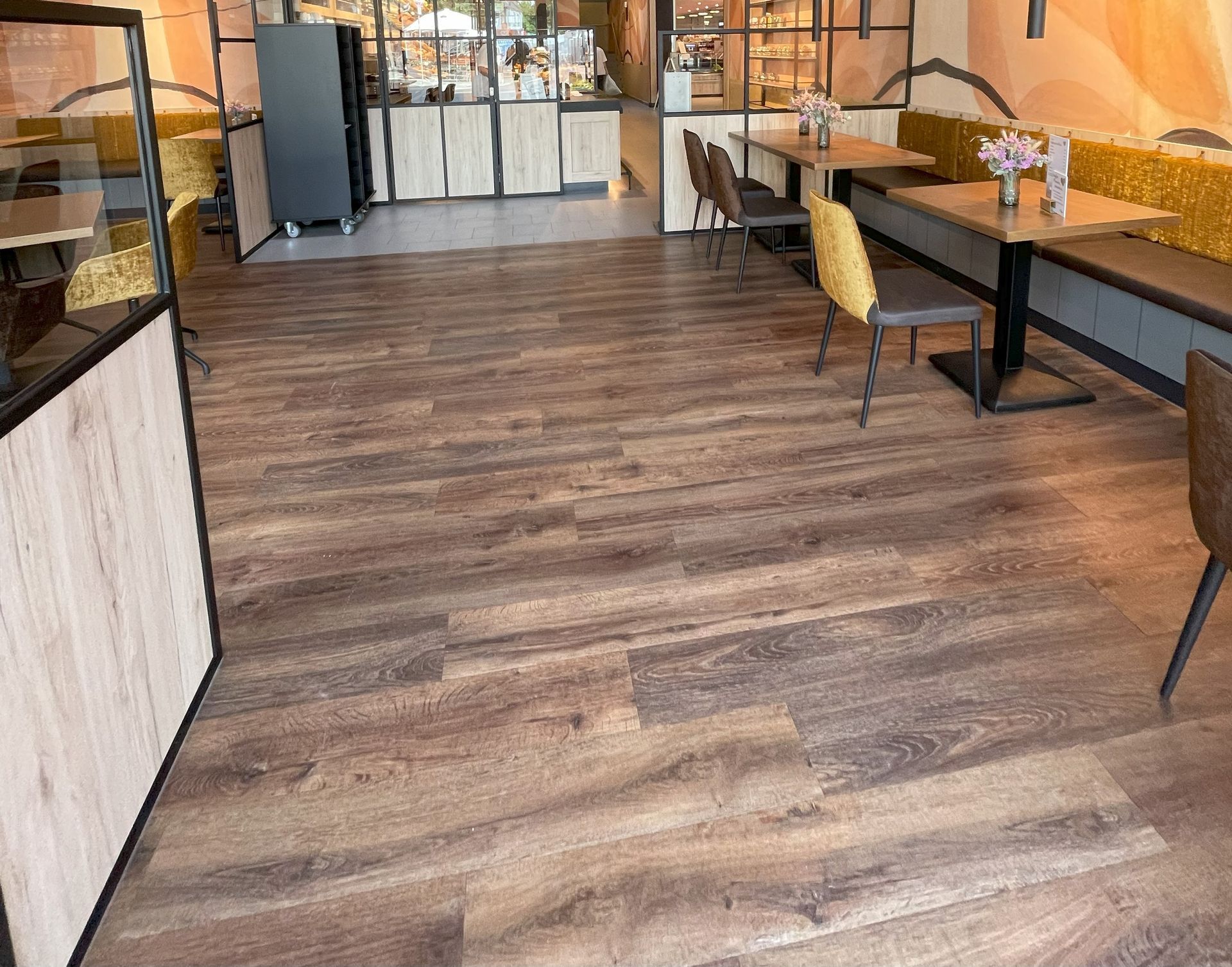 Ein Restaurant mit Holzböden und Tischen und Stühlen.