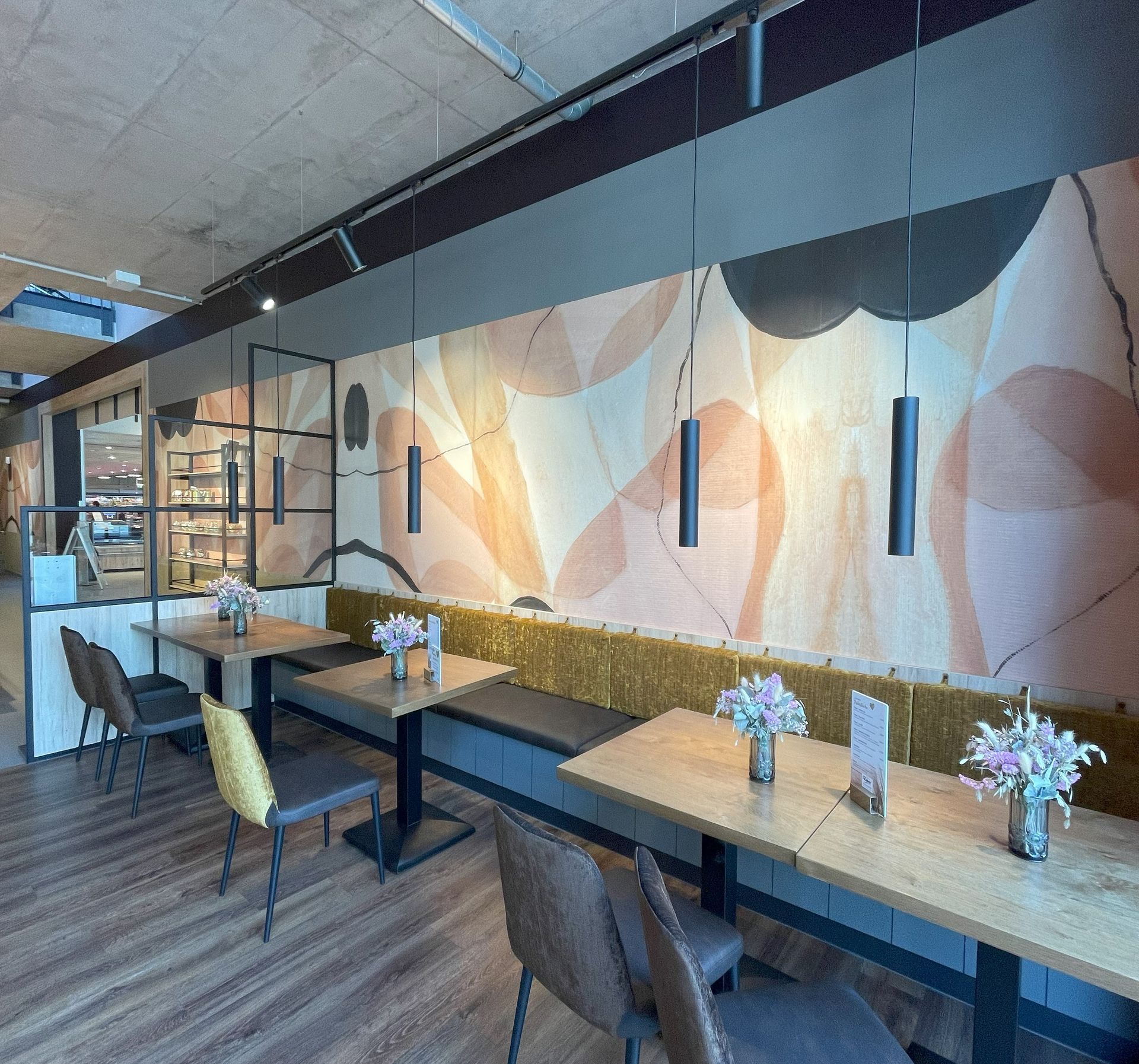 Ein Restaurant mit Tischen und Stühlen und einem Wandgemälde an der Wand.