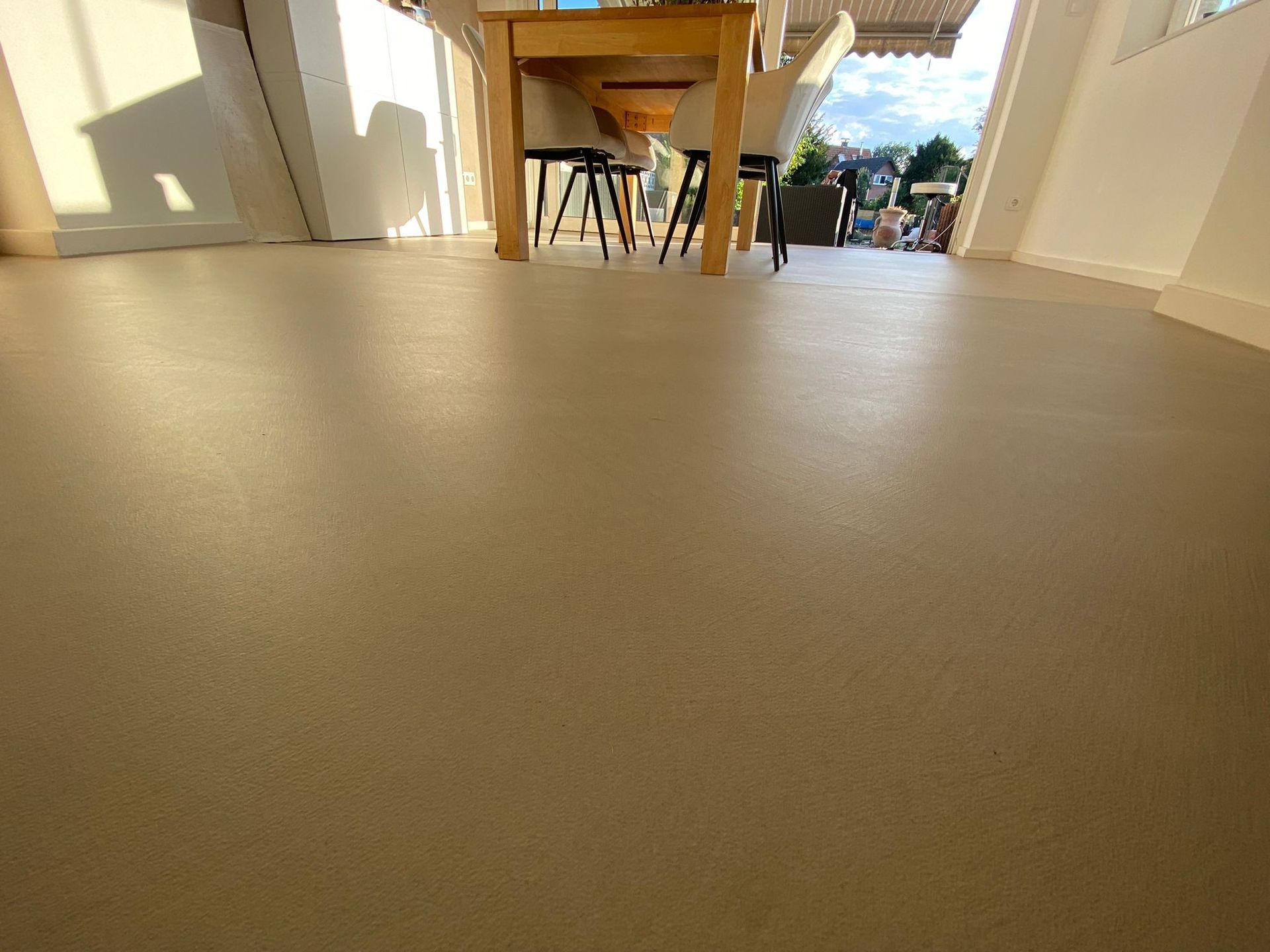 Ein Esszimmer mit Tisch und Stühlen und Betonboden.