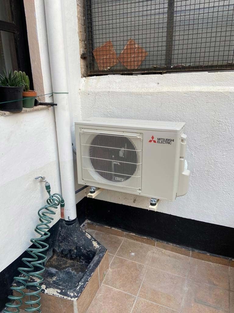 Un acondicionador de aire Mitsubishi está instalado en el lateral de un edificio.
