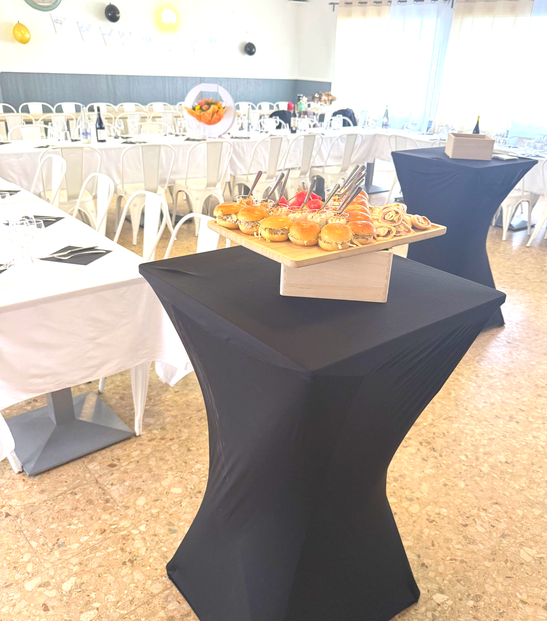 Plateau d'amuse-bouche sur un support en bois. Wraps, mini-sandwichs et desserts à étages avec cuillères.