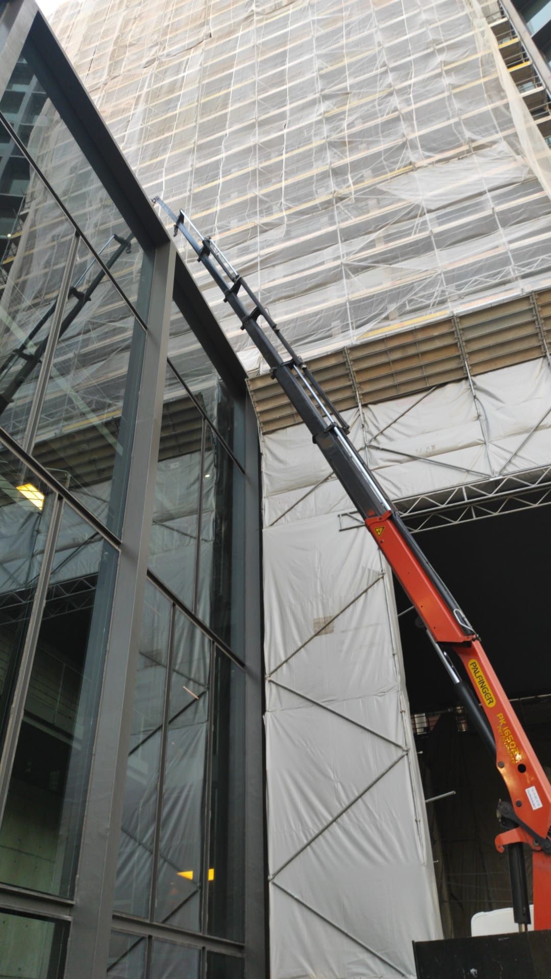 Se está utilizando una grúa para quitar una ventana de un edificio.