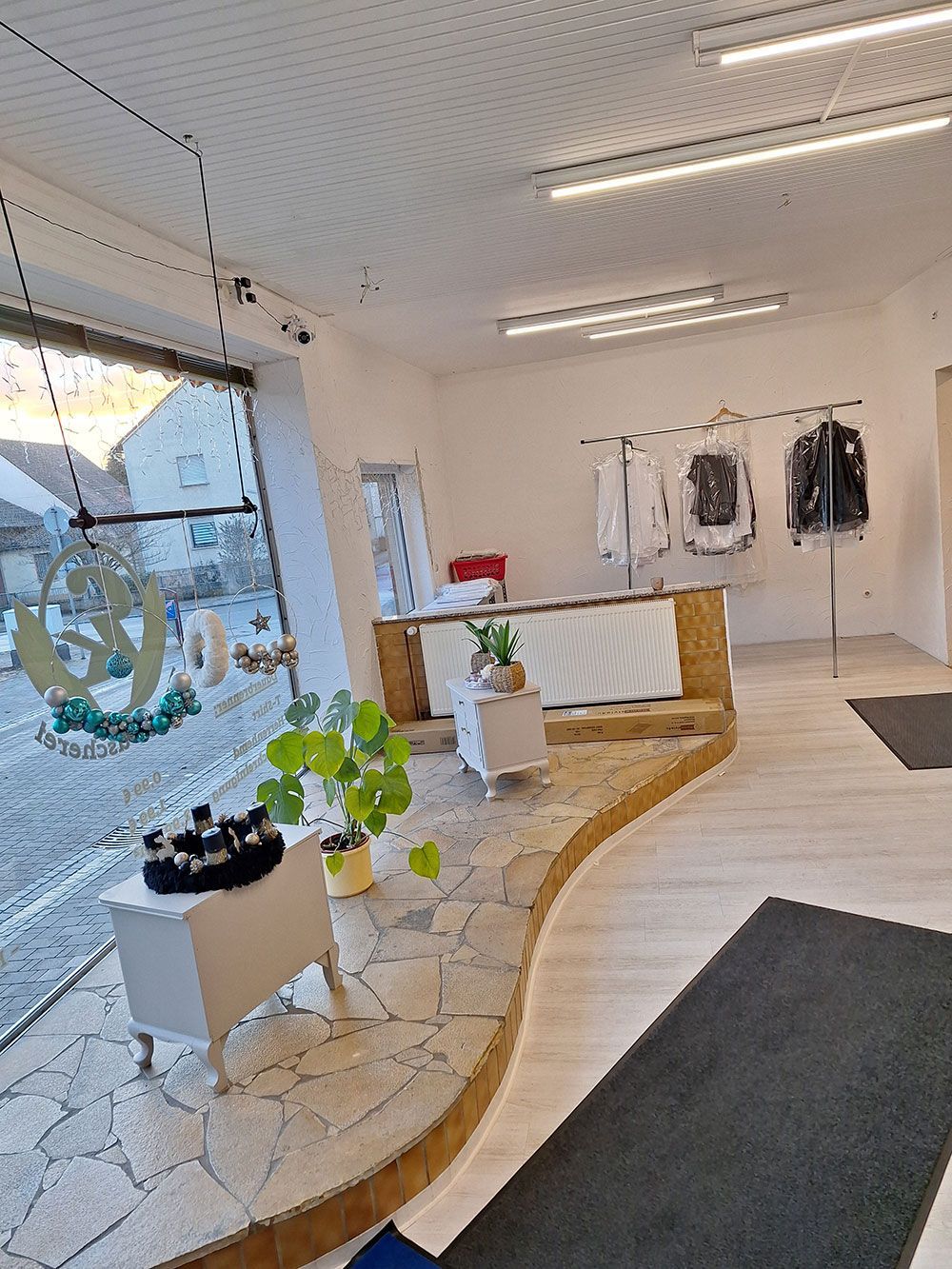 Ein Zimmer mit Holzboden und einem großen Fenster.