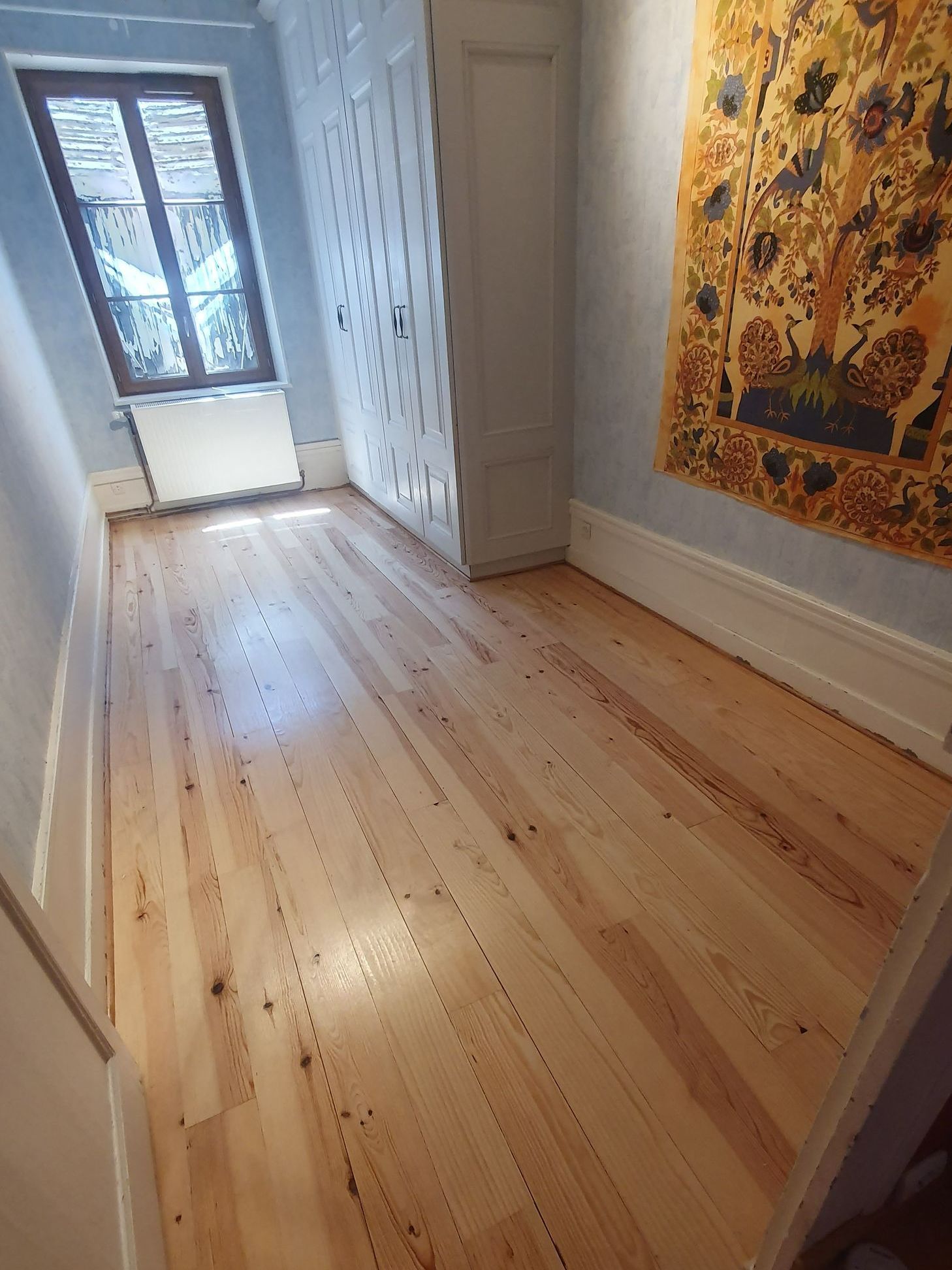 Parquet dans une pièce avec une tapisserie au mur