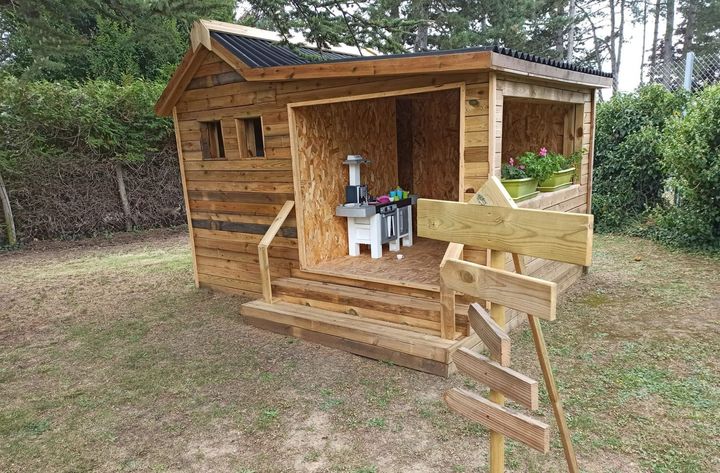 Une cabane en bois et un panneau