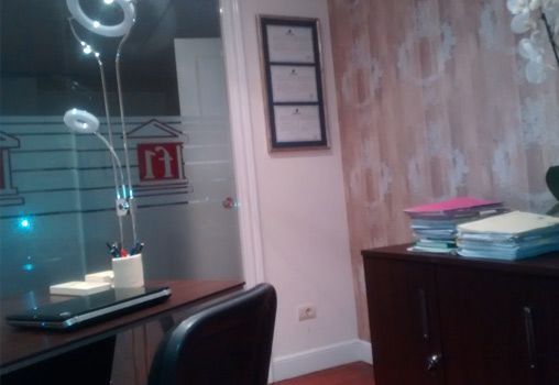 Un escritorio con una computadora portátil y una pila de papeles encima.