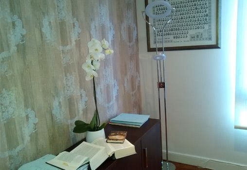 Una lámpara está sobre una mesa al lado de una planta.